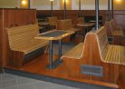Dřevěné pódium, lavice, stoly, kryty radiátorů, odkladní skříň na použité tácy