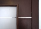 Prosklené interiérové dveře s vypískovanými a nerezovými proužky - detail
